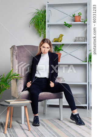 Girl in jeans and jacket sitting in armchair in Girl in jeans and jacket sitting in armchair in 60331283