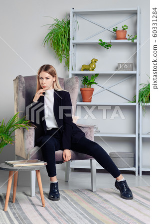 Girl in jeans and jacket sitting in armchair in Girl in jeans and jacket sitting in armchair in 60331284