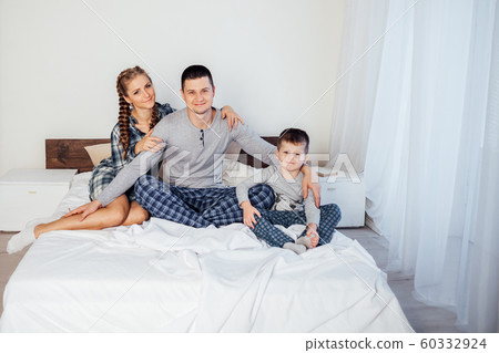 mom dad and son lie on the bed at home dream 60332924