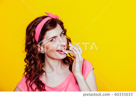 girl in pink dress pinup-style eats cream licks fingers girl in pink dress pinup-style eats cream licks fingers 60333033