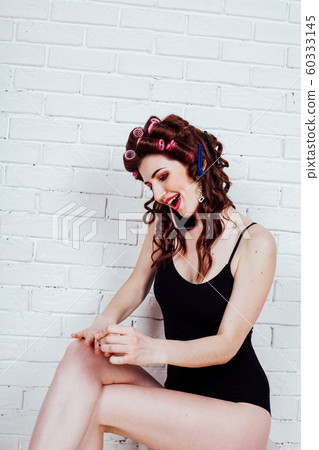 girl with hair curlers talking on the phone and paint nails girl with hair curlers talking on the phone and paint nails 60333145