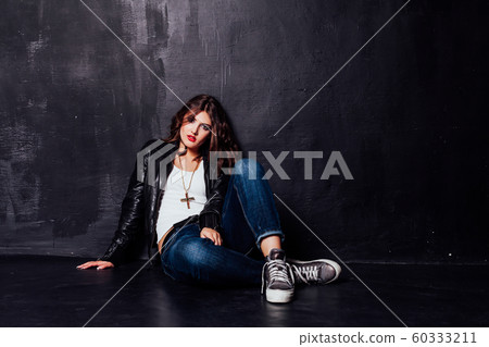 girl in leather jacket pitchman style on a black background 60333211