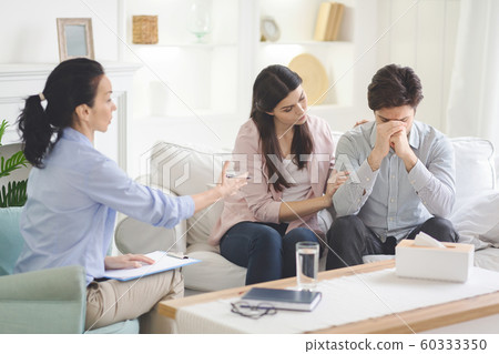 Loving wife supporting her husband during psychotherapy session Loving wife supporting her husband during psychotherapy session 60333350