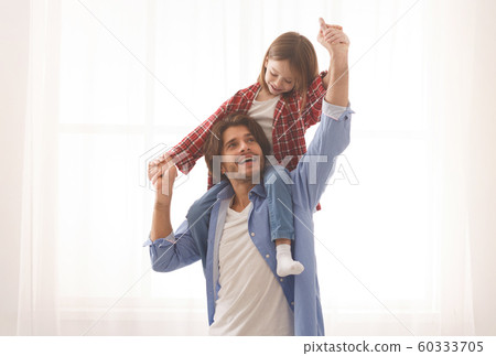 Cute little girl playing with her cheerful father Cute little girl playing with her cheerful father 60333705