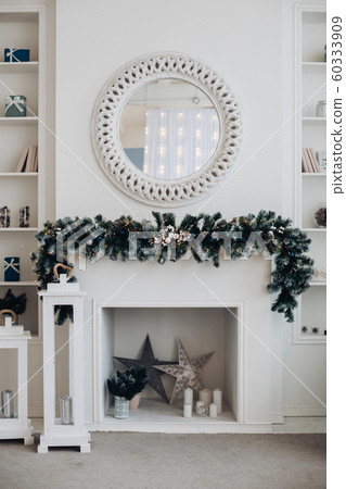 Beautiful fireplace with mirror and fur branches. Beautiful fireplace with mirror and fur branches. 60333909
