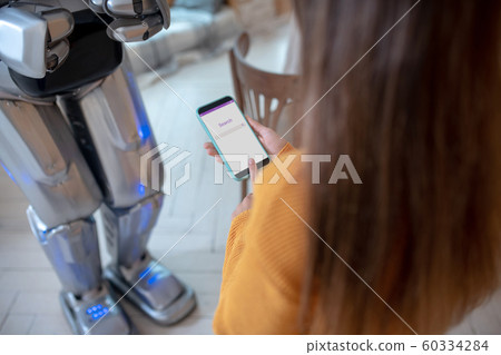 Girl with long hair holding a smartphone in her hand Girl with long hair holding a smartphone in her hand 60334284