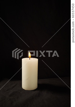 Burning candle on a black background isolated 60337450