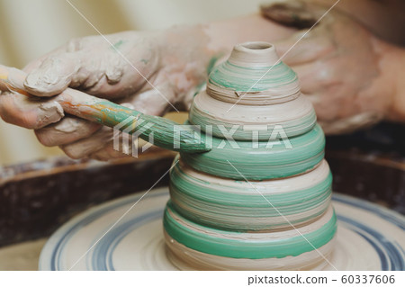 Hands on pottery wheel. Craftsman artist painting Hands on pottery wheel. Craftsman artist painting 60337606