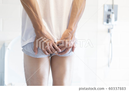 Closeup man holding bladder with pee pain 60337883