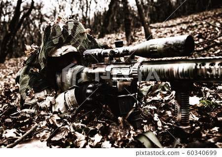 Army sniper hiding on ground in forest leaves Army sniper hiding on ground in forest leaves 60340699