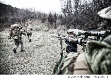 Commando army soldiers fighters squad rushing in woodland 60340801