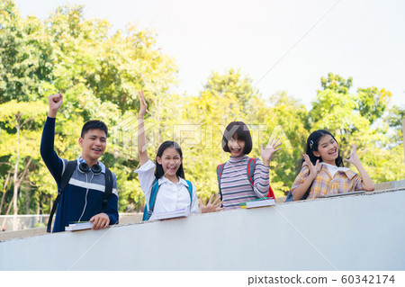Group of students standing together over wall Group of students standing together over wall 60342174