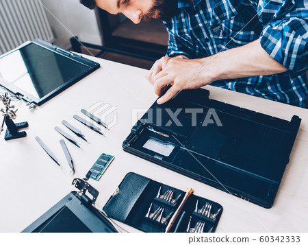 tech support engineer disassembling laptop tools 60342333