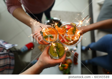 Young group friends hold in hand cocktail with sparkler 60343589