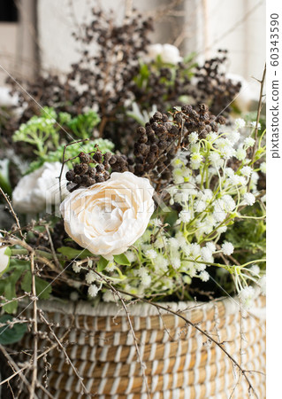 Arrangement of white flowers and dried flowers in a wicker basket 60343590