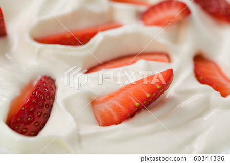 Closeup of fresh chopped strawberries in white yogurt Closeup of fresh chopped strawberries in white yogurt 60344386