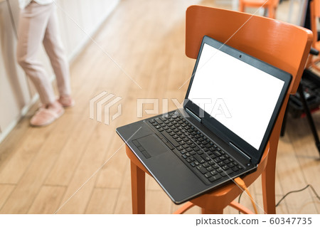 Notebook with clipped display placed on a orange chair, workplace with hardware equipment Notebook with clipped display placed on a orange chair, workplace with hardware equipment 60347735
