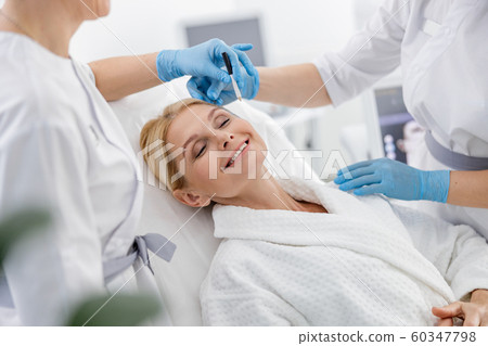 Smiling adult woman with closed eyes on the couch in beauty salon 60347798