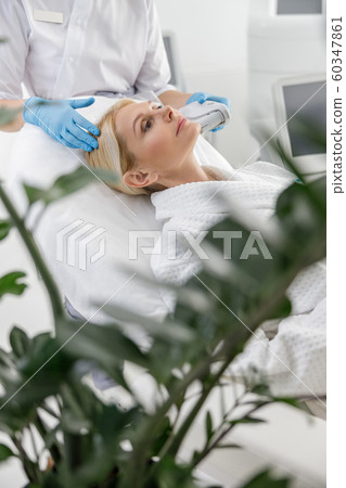 Adult woman during a painless procedure in beauty salon Adult woman during a painless procedure in beauty salon 60347861