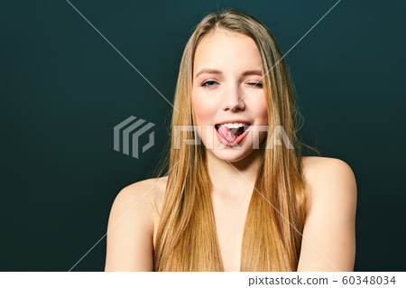 Young crazy lady. Music lover rock fan concept. Close up photo portrait of excited funky funny comic cheerful lady making stick tongue out sign isolated on a black background Young crazy lady. Music lover rock fan concept. Close up photo portrait of excited funky funny comic cheerful lady making stick tongue out sign isolated on a black background 60348034