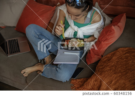Pretty lady sitting with notebook and food Pretty lady sitting with notebook and food 60348156
