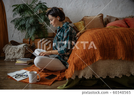 Pretty young woman is typing on laptop in bedroom Pretty young woman is typing on laptop in bedroom 60348565