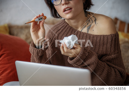 Upset young woman is demonstrating thermometer at home Upset young woman is demonstrating thermometer at home 60348856