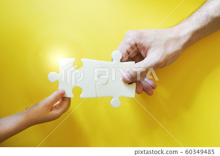 Child and father hands taking pieces of puzzle. Child and father hands taking pieces of puzzle. 60349485