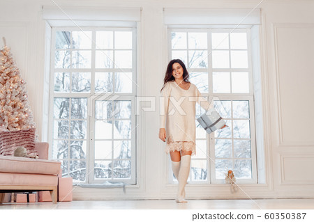 Beautiful young girl in white dress posing on camera. Christmas concept Beautiful young girl in white dress posing on camera. Christmas concept 60350387