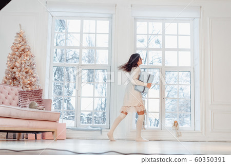 Beautiful young girl in white dress posing on camera. Christmas concept Beautiful young girl in white dress posing on camera. Christmas concept 60350391