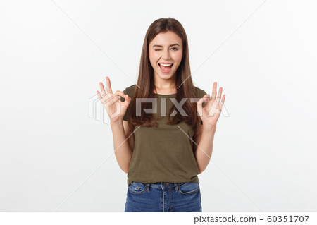Happy young woman showing ok sign with fingers an winking isolated on a gray background. 60351707