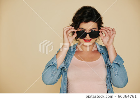 Woman putting on sunglasses 60364761