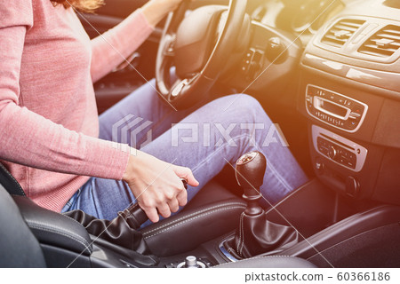 Female hand pulling handbrake in the car. Woman driving car Female hand pulling handbrake in the car. Woman driving car 60366186