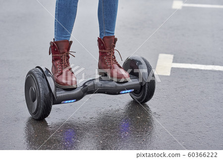 Close up of woman using hoverboard on asphalt 60366222
