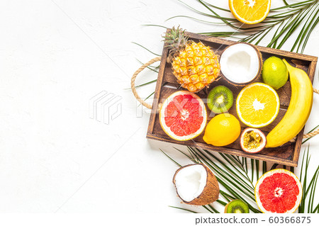 Tropical fruits and palm leaves on a white 60366875