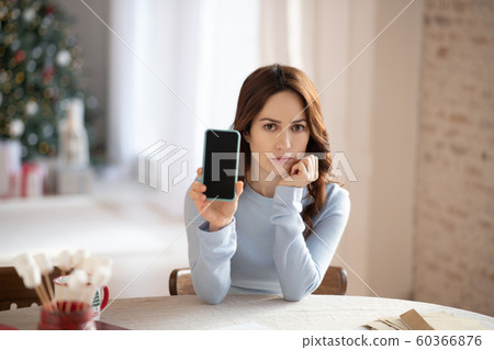 Dark-haired woman in gtey outfit looking moody 60366876