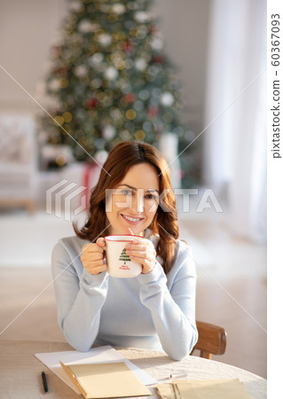 Pretty yuoung woman with cup in her hands spending christmas at home 60367093