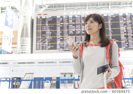 Airport lobby bulletin board woman mobile phone 60369875