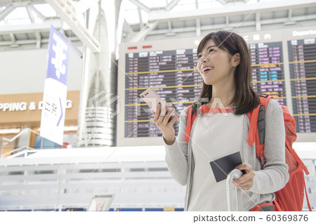 Airport lobby bulletin board woman mobile phone 60369876