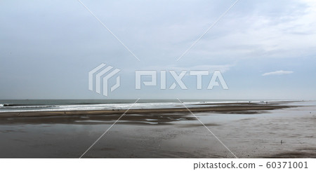 Beautiful tropical beach sunset sky and ocean wave forms a quiet silence atmospheric emotion on a rainy cloudy overcast day. 60371001