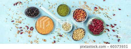 Legumes panorama, top-down shot on a blue background. Vibrant pulses including colourful red and black beans, lentils, soybeans, chickpeas, a flat lay 60373931