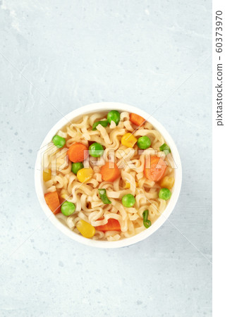 Instant noodles with vegetables in a plastic cup, shot form above with a place for text Instant noodles with vegetables in a plastic cup, shot form above with a place for text 60373970