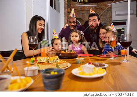 Portrait of happy family celebrating a birthday at home Portrait of happy family celebrating a birthday at home 60374317