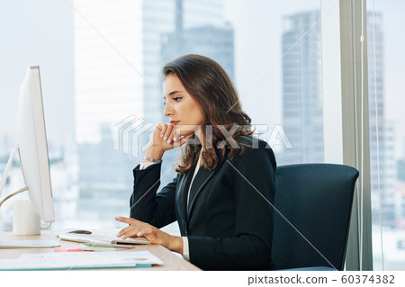 Businesswoman reading report on computer Businesswoman reading report on computer 60374382