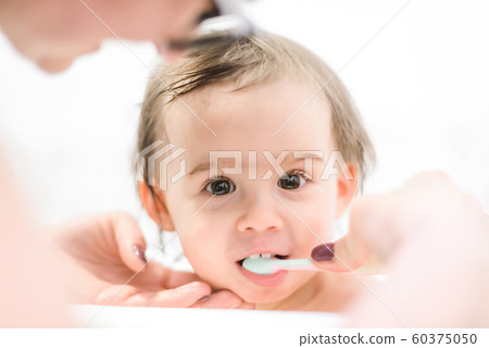 Happy 1 year old Baby in bathtubbrushing teeth in 60375050