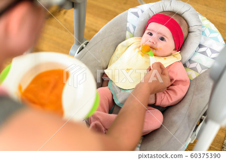 Mother feeding hungry five month old funny baby 60375390