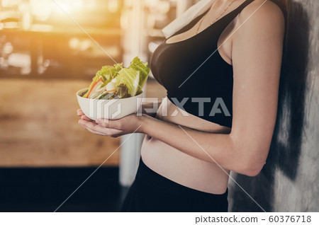 Beautiful young lady with salad in the Gym.  60376718