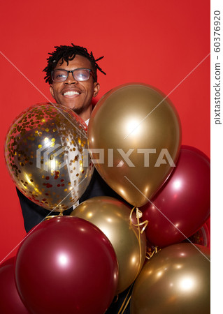 Handsome African Man Holding Balloons at Party 60376920