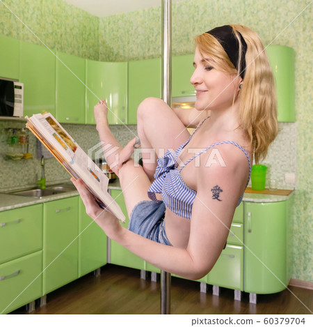 young woman reads cookbook while exercising in young woman reads cookbook while exercising in 60379704