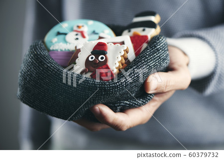 man with christmas cookies in his hands 60379732